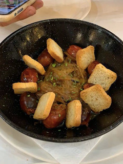 Una foto de Choricitos a la sidra con cebolla caramelizada