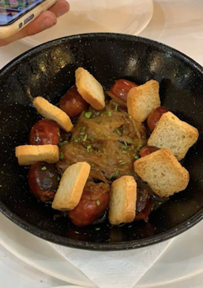 Una foto de Choricitos a la sidra con cebolla caramelizada