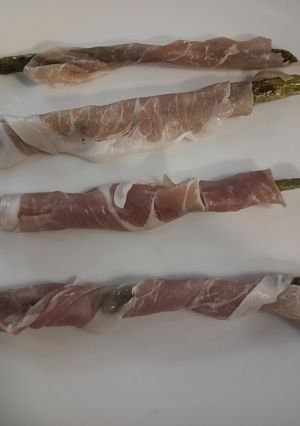 A picture of Asparagus wrapped in prosciutto ham.