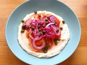 Una foto de humus con albahaca