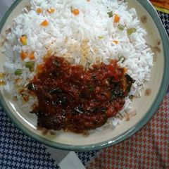 A picture of White rice with carrots and green peas,and tomatoe sauce.