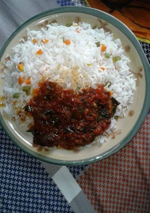 A picture of White rice with carrots and green peas,and tomatoe sauce.