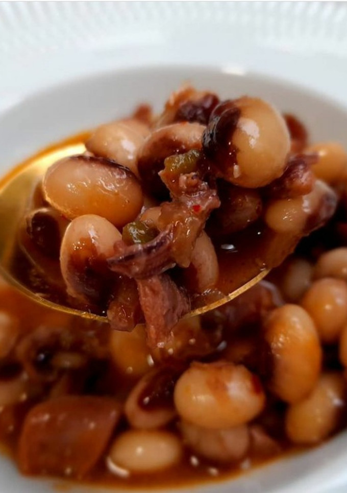 Una foto de Guiso de alubias caparrón con calamar encebollado