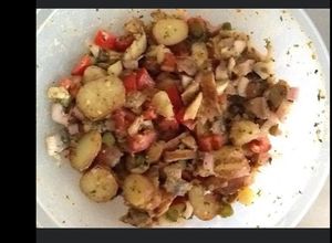 Une photo de Salade de pommes de terre tomates oignons et harengs fumés
