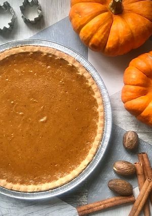 A picture of Pumpkin Pie with Cream & Maple syrup.