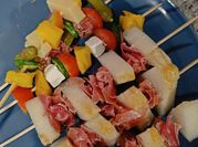 Una foto de brocheta de tomate, jamon