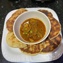 Naan bread with spicy chicken masala sauce A picture of Naan bread with spicy chicken masala sauce.