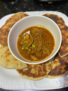 A picture of Naan bread with spicy chicken masala sauce.