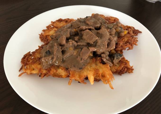 Beef goulash with mushrooms served on potato pancakes