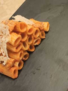 Una foto de Rigatoni con tomate y teja de queso parmesano