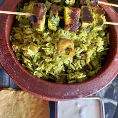 Hariyali Paneer Tikka Biryani with Raita A picture of Hariyali Paneer Tikka Biryani with Raita.
