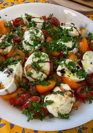 Une photo de Salade de tomates cerises bicolores à la mozzarella, persil et crème de balsamique