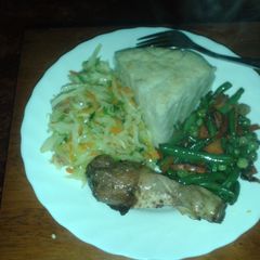 A picture of Ugali served with roasted chicken, steamed cabbage and mixed veggies.