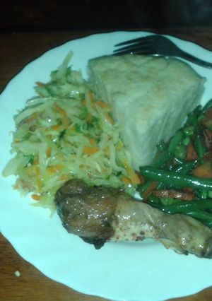A picture of Ugali served with roasted chicken, steamed cabbage and mixed veggies.