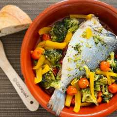 Una foto de Dorada al horno con jamón y cama de verduritas