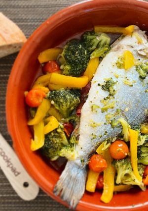 Una foto de Dorada al horno con jamón y cama de verduritas