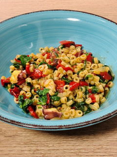Una foto de Pasta corta con pulpo, espinacas y piquillo