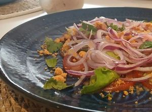 Una foto de Carpaccio de Tomate Pera y Corazones de Romana con Cebolla Dulce de Fuentes y Vinagreta de Moscatel
