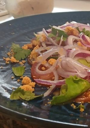 Una foto de Carpaccio de Tomate Pera y Corazones de Romana con Cebolla Dulce de Fuentes y Vinagreta de Moscatel
