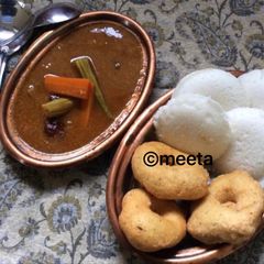 A picture of Andhra style Uddina vada and Idli served with sambhar.