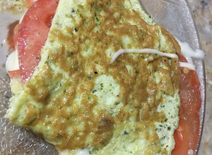 Una foto de Omelette de huevo, pesto rúcula con queso y tomate