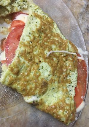 Una foto de Omelette de huevo, pesto rúcula con queso y tomate