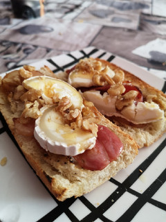 Una foto de Tosta de bacon, queso de cabra, nueces y miel