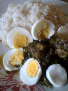 A picture of Ofada rice,Vegetable stew,beef and Boiled Eggs.