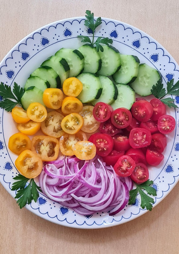 Una foto de Ensalada multicolor de tomates cherry rojos y amarillos con cebolla morada y pepino ❤️💛💜💚