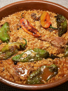 Una foto de Cazuela de arroz, con chuletas de cordero y pimientos fritos