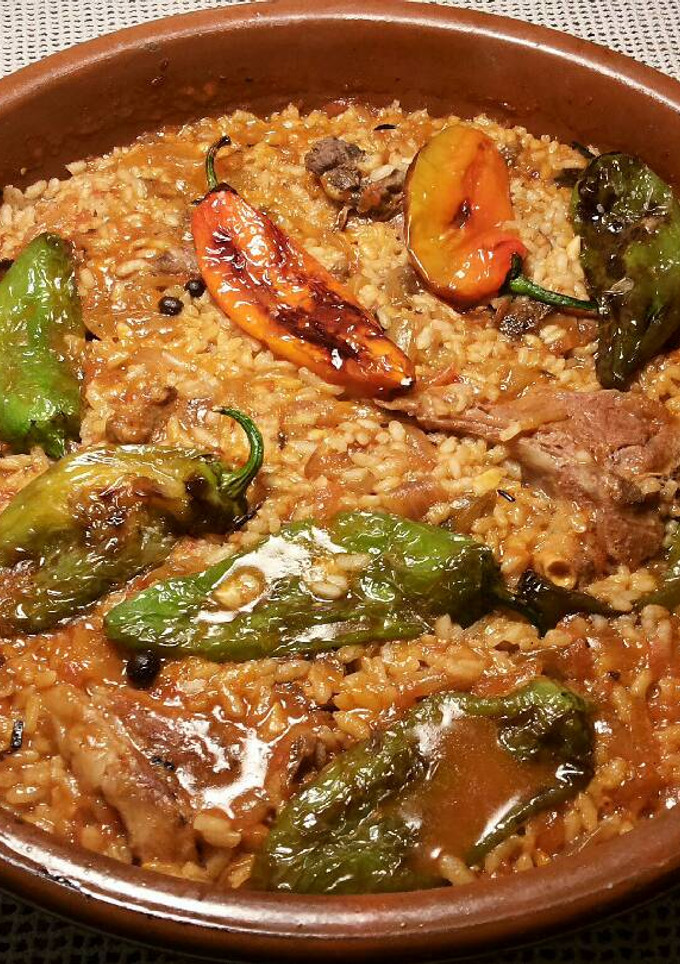 Una foto de Cazuela de arroz, con chuletas de cordero y pimientos fritos