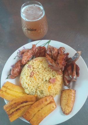 Una foto de Arroz con verduras acompañado de alas BBQ con maduro frito