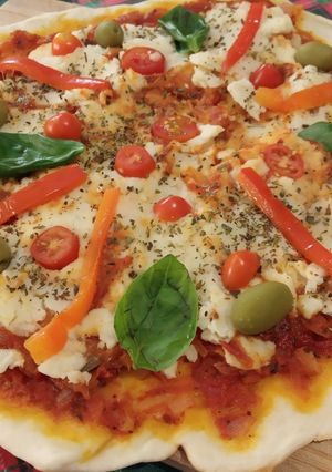 Una foto de Pizza vegana con albahaca, tomates cherry y morrón 🍕