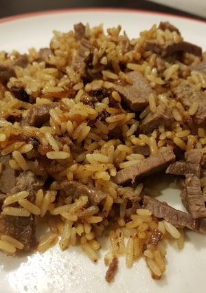Una foto de Arroz con cebolla y carne. Tipo wok pero en sartén