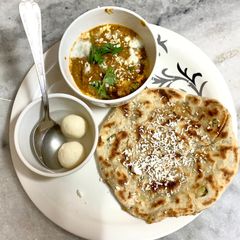 A picture of Stuffed paratha and butter masala paneer.