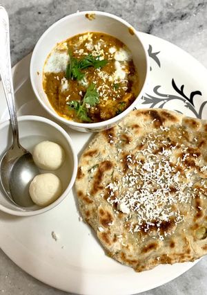 A picture of Stuffed paratha and butter masala paneer.