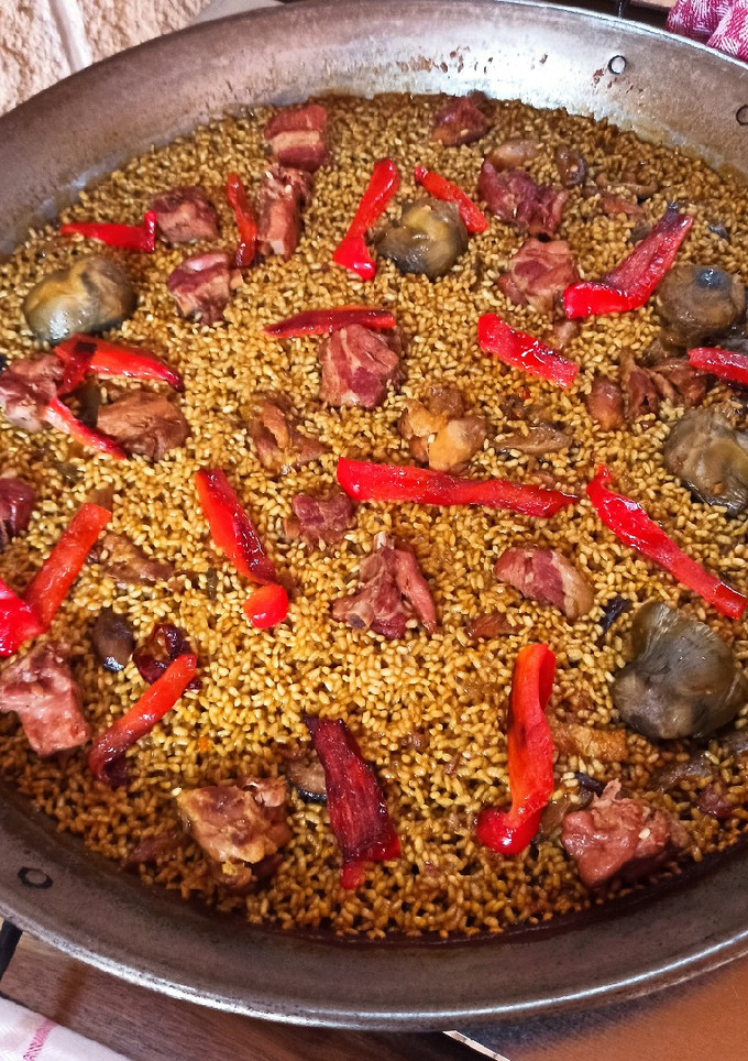 Una foto de Paella con costilla de ibérico, pollo y alcachofas