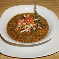 A picture of Vegan lentil soup with crispy tortilla strips.