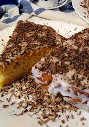 Una foto de Tarta de calabaza y almendra con glaseado de limón y virutas de chocolate