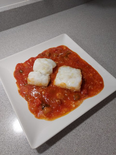 Una foto de Bacalao al horno sobre cama de fritada