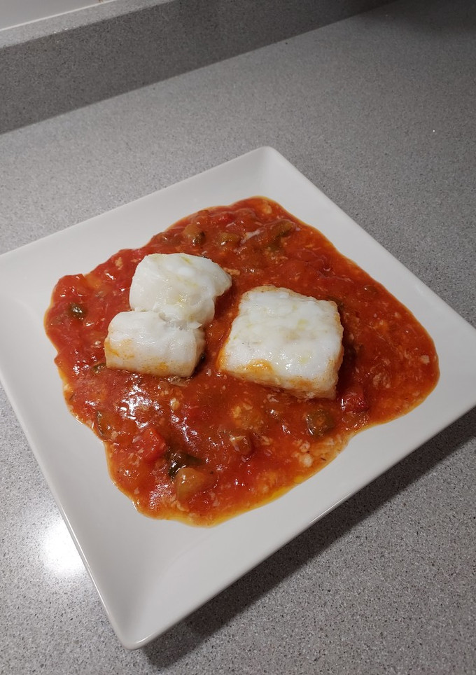 Una foto de Bacalao al horno sobre cama de fritada