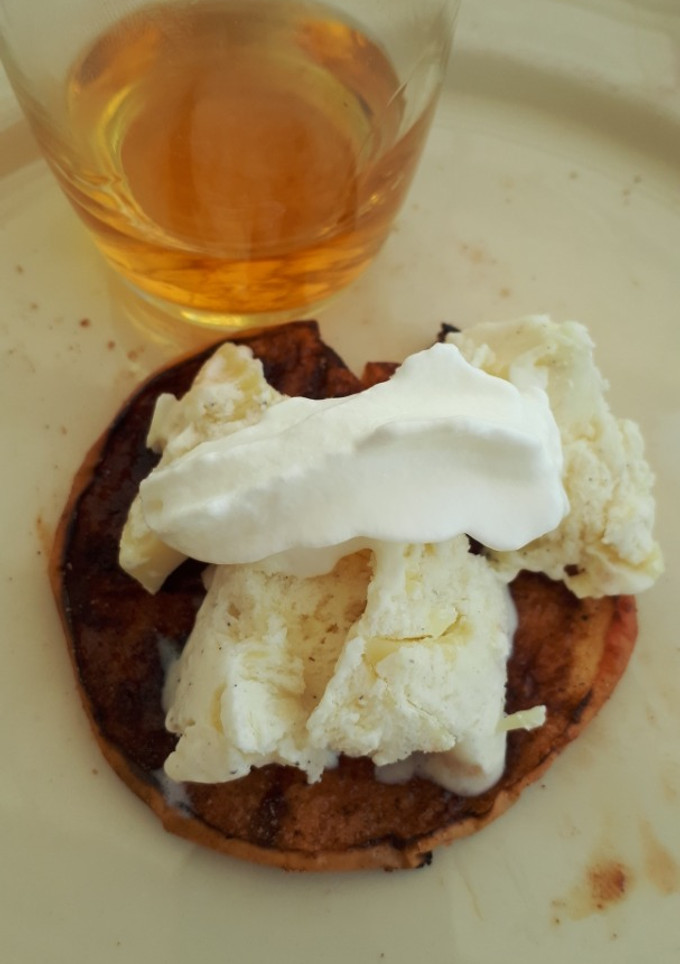 Una foto de Manzana asada en barbacoa con topping de helado y nata