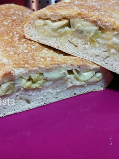 Una foto de Stromboli relleno de alcachofas