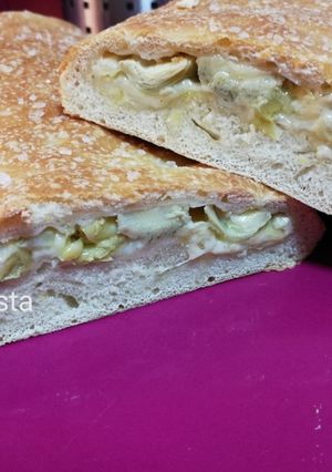 Una foto de Stromboli relleno de alcachofas