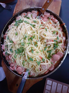 Una foto de Tallarines con salsa de crema y salchichas