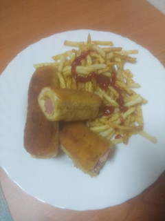 Una foto de Hot dog enrollado y frito con papas fritas