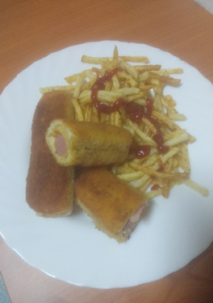 Una foto de Hot dog enrollado y frito con papas fritas