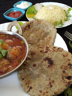 A picture of Kathiyavadi stuff onion with bajra roti and jeera rice.