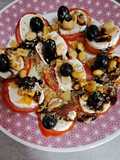 Ruleta de tomates con queso fresco, frutos secos, aceitunas y orégano