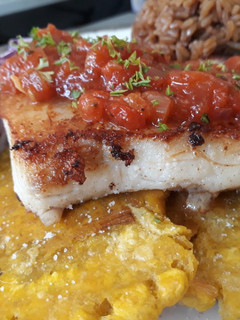 Una foto de Filete de róbalo con patacones y ahogado al estilo caribeño